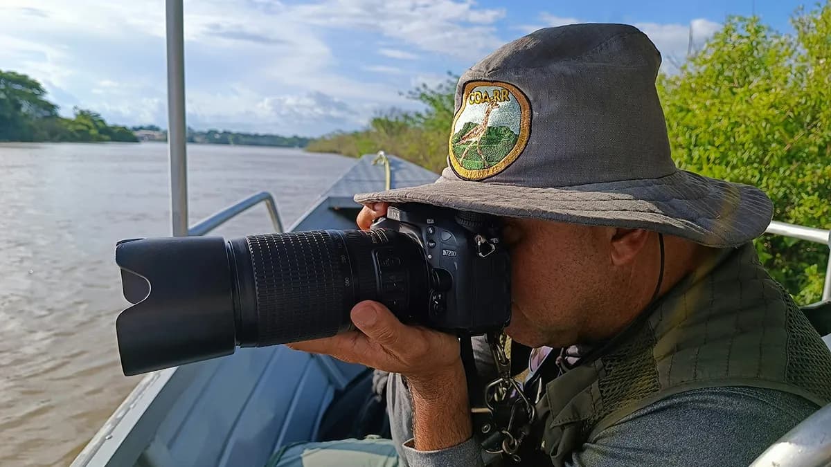 Un guardaparque de la red fotografía la orilla desde un bote en el río
